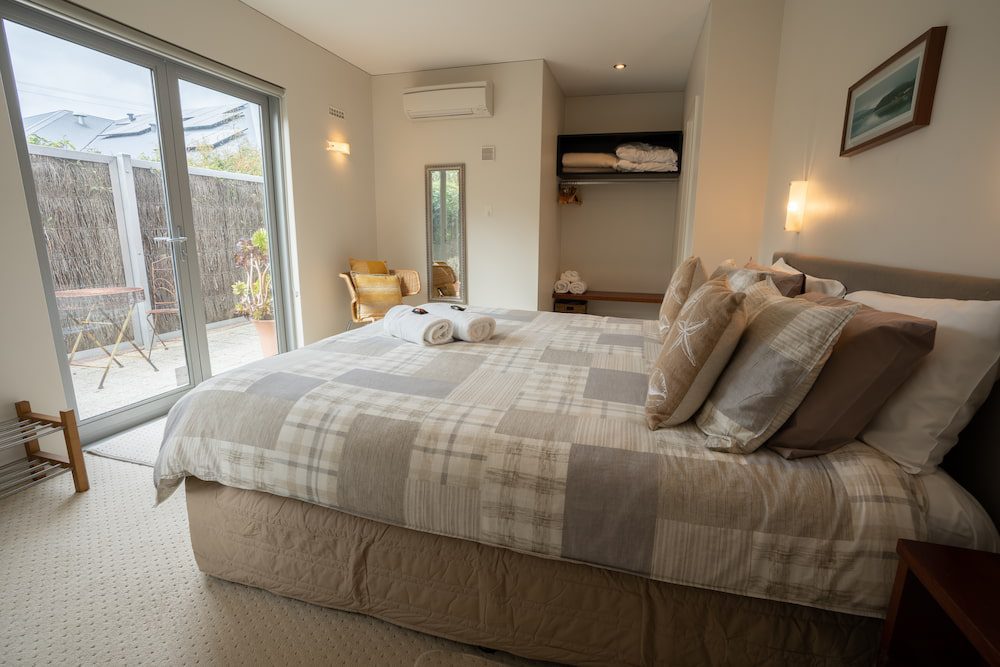 The master bedroom of the Lockyer Apartment with double door to a small outdoor sitting area.