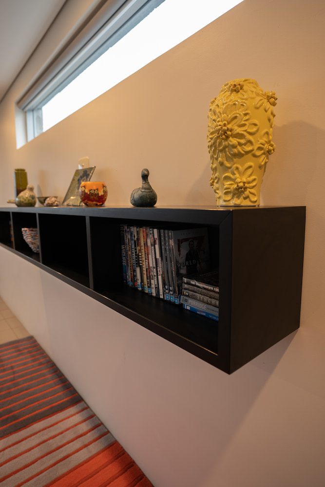 The bookshelf in the Lockyer Apartment with objet d'art and DVDs.